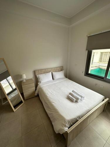 a bedroom with a bed with two towels on it at Modern city center studio saripolou in Limassol