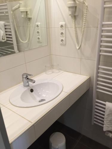 a white bathroom with a sink and a mirror at Haus am Wald in Eltmann