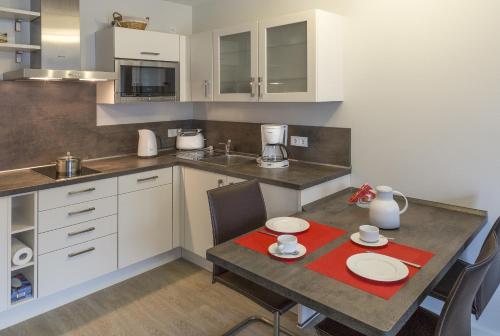 eine Küche mit einem Tisch mit zwei Platten drauf in der Unterkunft Apartment Residenz am Balmer See Wohnung 44 mit Wellnessbereich in Balm