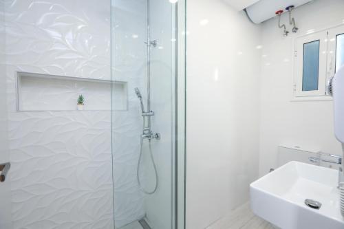 a white bathroom with a shower and a sink at Arcade Game House-Luxury studio in Corfu Town in Agios Rokkos