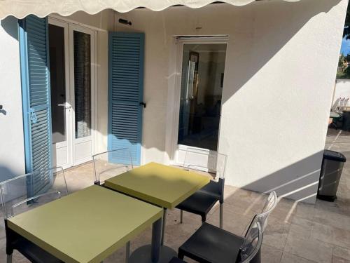 deux tables et chaises devant un bâtiment dans l'établissement Super appartement avec terrasse, centre ville, à Saint-Tropez