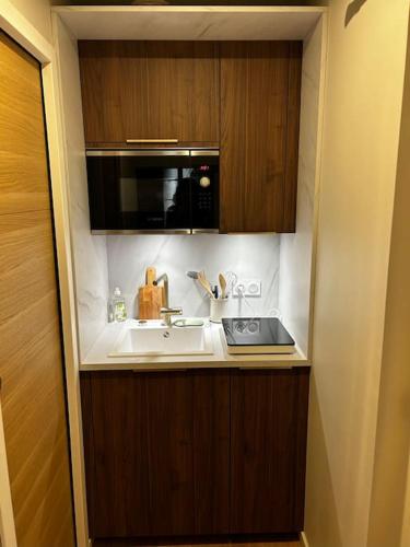 une cuisine avec un évier et un micro-ondes dans l'établissement La Suite Tourny, à Bordeaux