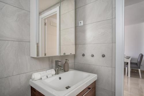 a white bathroom with a sink and a mirror at Seaview terrace with pool in Carvajal Ref 103 in Torremuelle