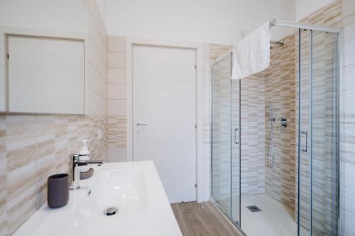 a bathroom with a tub and a sink and a shower at Campanella Rooms in Locri