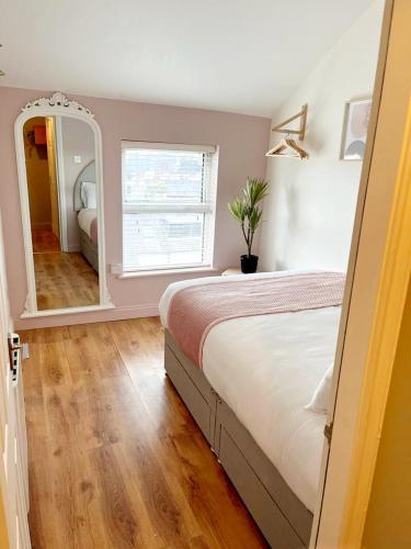 1 dormitorio con 1 cama grande y espejo en 'Bridgewater' at stayBOOM, en Morecambe