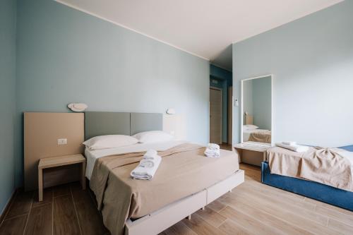 a bedroom with two beds and a mirror at Campanella Rooms in Locri