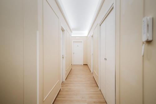 an empty hallway with white walls and wooden floors at Campanella Rooms in Locri