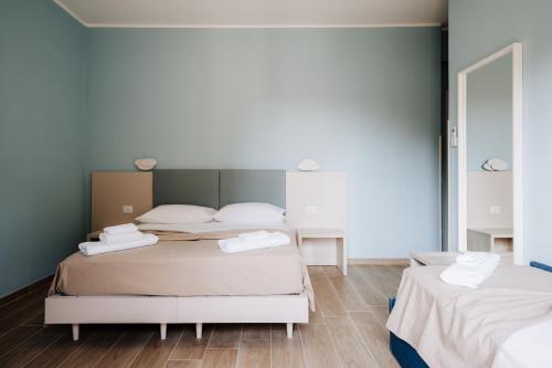 a bedroom with two beds and a mirror at Campanella Rooms in Locri