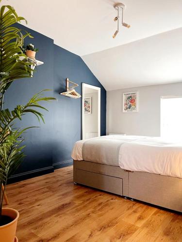 1 dormitorio con cama y pared azul en 'Bridgewater' at stayBOOM, en Morecambe