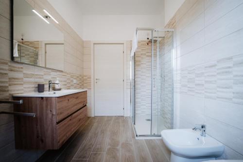 a bathroom with a toilet and a sink and a shower at Campanella Rooms in Locri