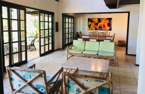 uma sala de estar com cadeiras verdes e uma mesa em Casa Charme 5 Suítes e areá gourmet - Praia da Pipa by PipaCharme em Pipa