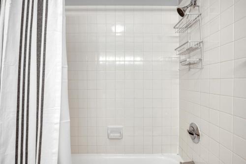 a white bathroom with a shower and a tub at Streeterville Studio w pool gym nr Navy Pier CHI-787 in Chicago
