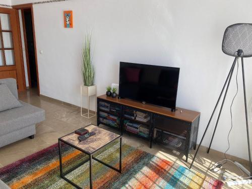 a living room with a flat screen tv on a table at Casa Balcones - Benalmadena Pueblo in Benalmádena