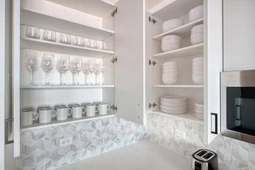 une cuisine avec des verres et des assiettes sur des étagères dans l'établissement Logan Square 2br w pool lounge gym nr L CHI-869, à Chicago