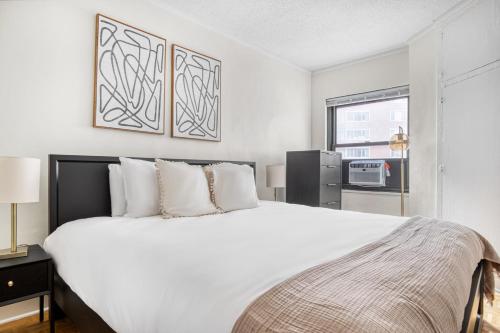 een slaapkamer met een groot wit bed en een raam bij Gold Coast 1BR w Doorman Gym 2 blocks to L CHI-551 in Chicago
