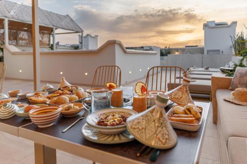 een ontbijttafel met eten op een balkon bij Riad Nyla Wellness and Spa in Marrakesh