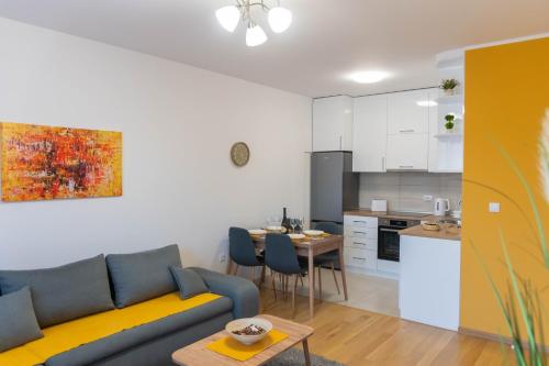 uma sala de estar com um sofá e uma cozinha em Apartman Exclusive em Obrenovac