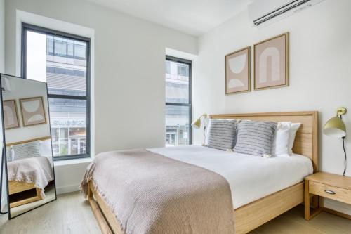 a white bedroom with a large bed and windows at Downtown Brooklyn 2BR w WD nr Barclays Center NYC-657 in Brooklyn