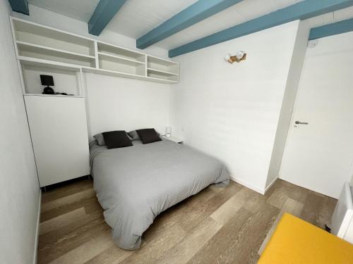 ein Schlafzimmer mit einem Bett in einem weißen Zimmer in der Unterkunft Le Petit Canada - Proche ville in La Rochelle