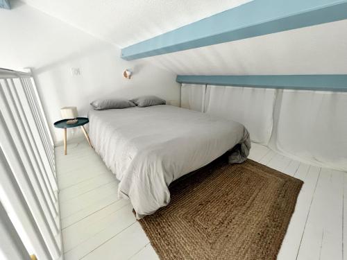 ein Schlafzimmer mit einem Bett mit blauer Decke in der Unterkunft Le Petit Canada - Proche ville in La Rochelle