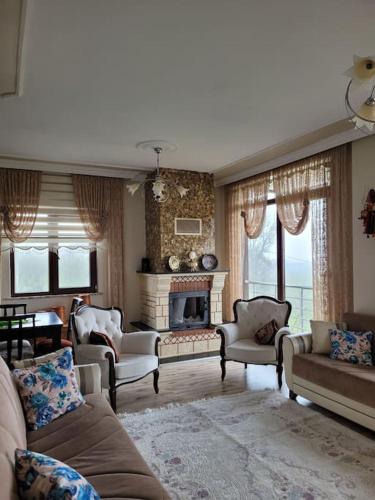 a living room with a couch and chairs and a fireplace at Trabzon Deniz Manzaralı villa in Araklı