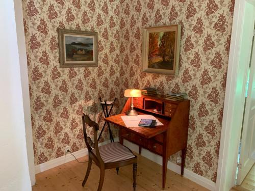 a desk with a lamp and a chair in a room at Villa Skuleskogen in Docksta