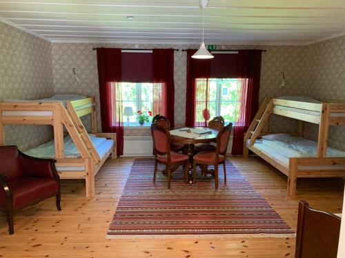 a room with two bunk beds and a table and chairs at Villa Skuleskogen in Docksta