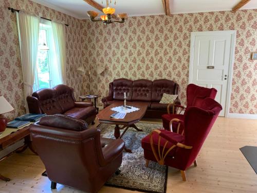 a living room with couches chairs and a table at Villa Skuleskogen in Docksta