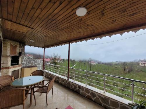 a patio with a table and chairs on a balcony at Trabzon Deniz Manzaralı villa in Araklı