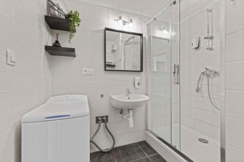een witte badkamer met een wastafel en een douche bij LAM Waves w AC & Terrace in Bratislava