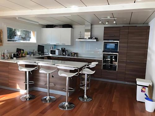una cocina con barra y taburetes. en Ultra Luxurious House Lake view en Niederried