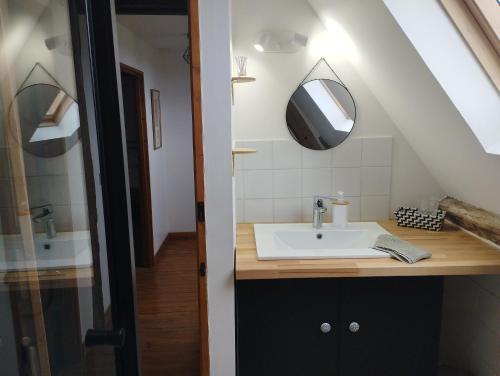 a bathroom with a sink and a mirror at La Ferme de Frévan in Sarceaux