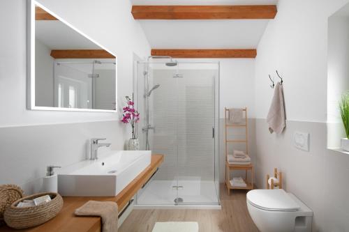 a white bathroom with a sink and a shower at House NoE- with hot tub in Bale