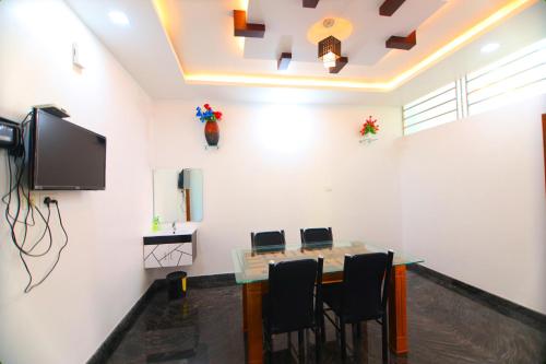 a meeting room with a table and a flat screen tv at SILVERY MOON GRAND VILLA in Tariyod