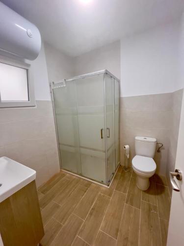 La salle de bains est pourvue de toilettes et d'une douche en verre. dans l'établissement RockSide Residences Suites La Línea N2, à La Línea de la Concepción
