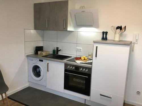 een keuken met een fornuis en een wasmachine bij Gemütliches Apartment am Kurhaus in Dobel in Dobel