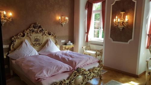 a bedroom with an ornate bed with white pillows at Schloss Sennfeld - Schloss Akademie & Eventlocation - in Adelsheim