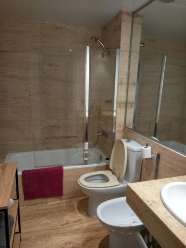 a bathroom with a toilet and a tub and a sink at Appart Cosy T3 (Vue Mer et Piscine 4-5 pers) in Blanes