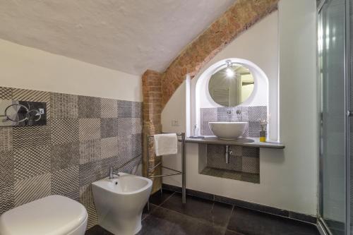 a bathroom with a sink and a toilet and a mirror at Affaccio sul Castellare in Siena