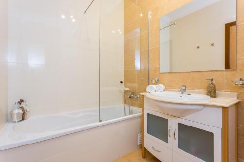 uma casa de banho com uma banheira, um lavatório e um chuveiro em Solemar - 2Pools - WIFI 500MBps - AC - Portimão em Portimão