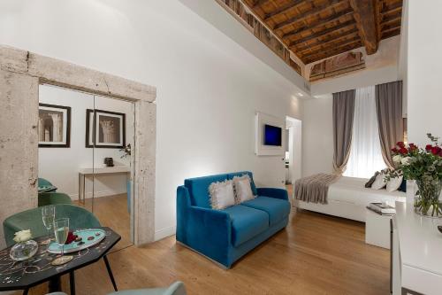 a living room with a blue chair and a bed at Argentina Residenza Style Hotel in Rome