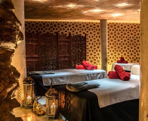 two beds with red pillows in a room at RIAD MEDINA MUDEJAR BAÑOS ARABES in Toledo