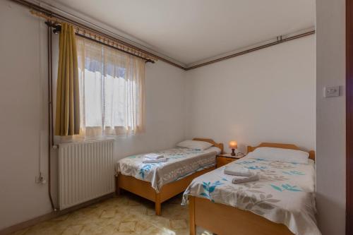 1 dormitorio con 2 camas y ventana en Apartments Crevatin, en Rovinj