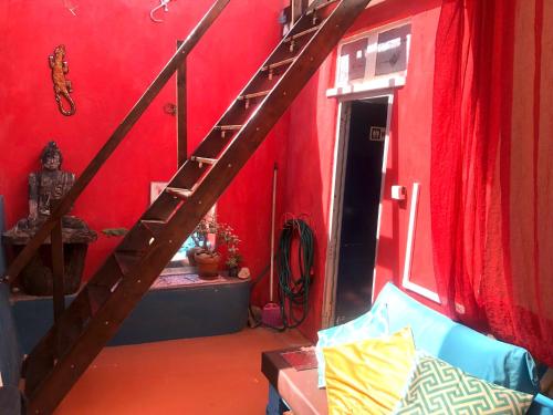 a room with a red wall with a wooden staircase at Buddha Bee - 18 to 35 years old only in Lagos