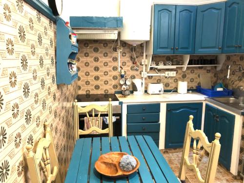 una cocina con armarios azules y una mesa y sillas azules en Buddha Bee - 18 to 35 years only en Lagos