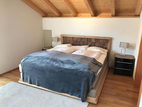 a bedroom with a large bed and a wooden ceiling at Ultra Luxurious House Lake view in Niederried
