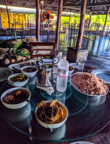 een glazen tafel met kommen eten erop bij Vintara Eco Resort in Hambantota