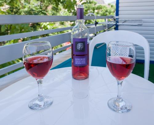 a bottle of wine and two glasses on a table at Klima Rooms in Palaiochóra