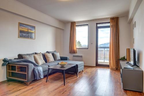 a living room with a couch and a tv at Complex Silver Hills in Smolyan