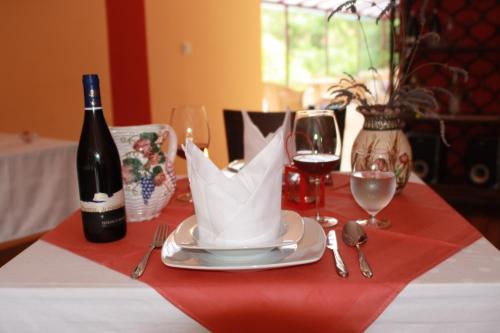 een tafel met een fles wijn en een bord met een wit servet bij Pensiune Safrane in Băile Herculane